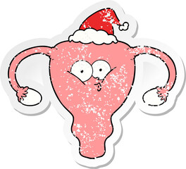 hand drawn distressed sticker cartoon of a uterus wearing santa hat
