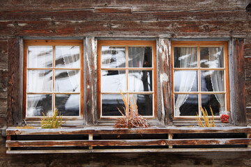 rustical window with wooden frame and view on snowy rooftop
