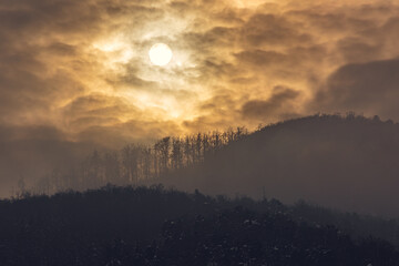 Sun in the clouds in mountains