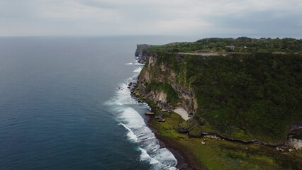 Fototapeta na wymiar A scenic aerial top view of ocean waves hitting the rocky cliff at Wedding Cake Rock beach in Sydney