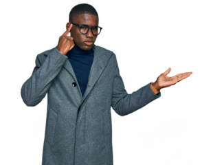 Young african american man wearing business clothes and glasses confused and annoyed with open palm showing copy space and pointing finger to forehead. think about it.