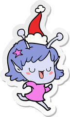 happy alien girl hand drawn sticker cartoon of a wearing santa hat