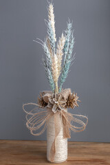 Painted wheat, bleached cones and jute in winter decor. Colored wheat. Symbol of Ukraine. Christmas...