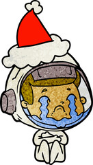 hand drawn textured cartoon of a crying astronaut wearing santa hat