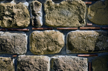 Old handcrafted stone wall. Close-up view of original brickwork. Typical architecture of Rome empire. Nature stone wall in Santo Stefano di Camastra, Sicily, Italy