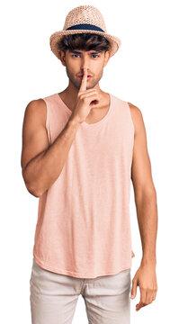 Young hispanic man wearing summer hat asking to be quiet with finger on lips. silence and secret concept.