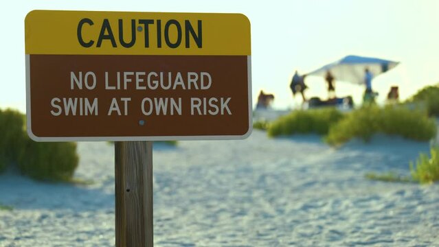 Warning sign poster on sea side beach saying that there is no lifeguard on duty