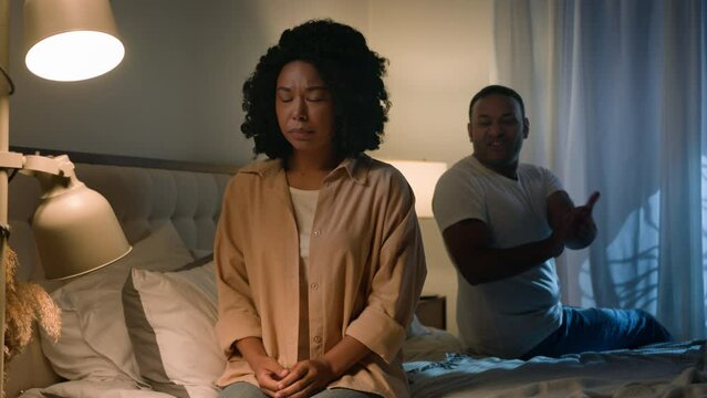 Couple quarrel sad African American woman feel desperate jealous husband angry man shouting accusing screaming yelling talking to wife breakup marriage divorce in bed night problem unwanted pregnancy