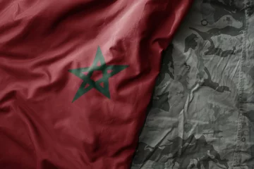 Foto auf Leinwand waving flag of morocco on the old khaki texture background. military concept. © luzitanija