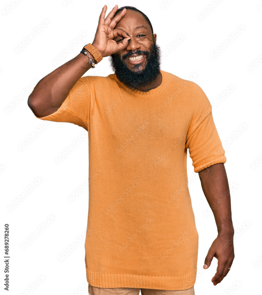 Poster Young african american man wearing casual clothes smiling happy doing ok sign with hand on eye looking through fingers