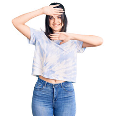 Fototapeta premium Young beautiful girl wearing casual t shirt smiling cheerful playing peek a boo with hands showing face. surprised and exited