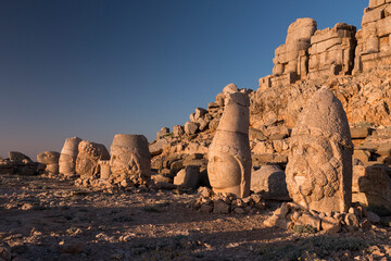 Statue heads of Herekles, Apollo & Zeus, with headless seated statues in front of the stone pyramid...