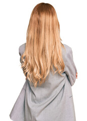 Naklejka premium Beautiful blonde young woman wearing business clothes standing backwards looking away with crossed arms
