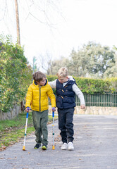 Boy walking with crutches with his friend on the street