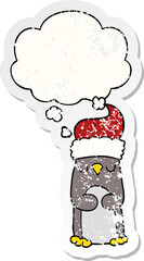 cartoon christmas penguin with thought bubble as a distressed worn sticker