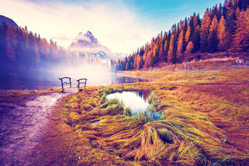mystical landscape with fog over the pond on a background of Tre Cime de Lavaredo mountains on the Antorno Lake, Dolomites Alps. (Meditation, anti-stress, relaxation - concept) - obrazy, fototapety, plakaty