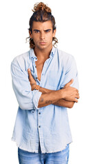 Young hispanic man wearing summer style skeptic and nervous, disapproving expression on face with crossed arms. negative person.