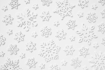 Festive pattern made of wooden snowflakes on a white background. Winter, Christmas, New Year concept.