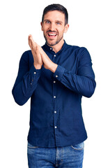 Young handsome man wearing casual shirt clapping and applauding happy and joyful, smiling proud hands together