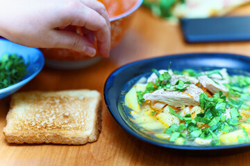Soup with chicken, potatoes, pasta and herbs