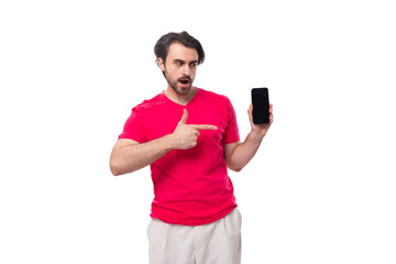 young handsome man with black hair dressed in a red t-shirt holds the phone screen forward