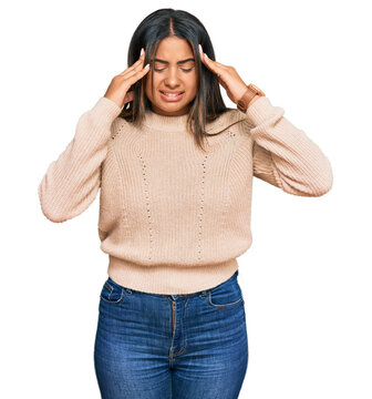 Young latin girl wearing wool winter sweater with hand on head, headache because stress. suffering migraine.