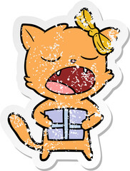 distressed sticker of a cartoon cat with christmas present
