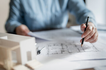 Interior architect or engineer working on blueprint at home office.