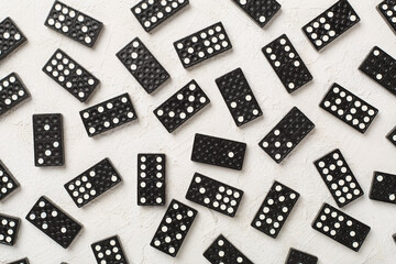 Black domino tiles on concrete background, top view