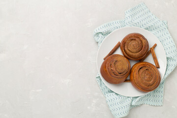 Obraz na płótnie Canvas Sweet homemade cinnamon rolls on concrete background, top view