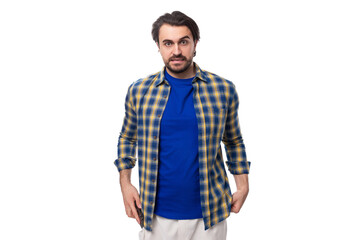 Fototapeta premium handsome young European brunette man with a well-groomed beard and mustache dressed casually in a summer look on a white background