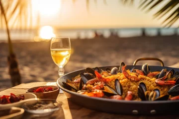 Zelfklevend Fotobehang Traditional spanish paella with seafood served in a pan on the table in a restaurant on the beach © Ilnara