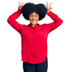 Young african american girl wearing casual clothes posing funny and crazy with fingers on head as bunny ears, smiling cheerful