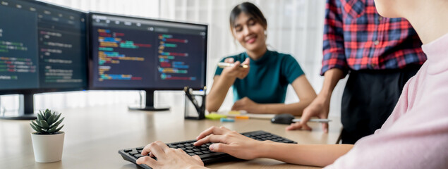 Young Professional website developer and cooperative computer engineer team brainstorming and sharing idea of program writing and coding at modern meeting room. Teamwork concept. Closeup. Burgeoning.