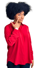Young african american girl wearing casual clothes pointing to the eye watching you gesture, suspicious expression