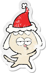 hand drawn distressed sticker cartoon of a bored dog wearing santa hat