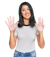 Beautiful asian young woman wearing casual white t shirt showing and pointing up with fingers number nine while smiling confident and happy.