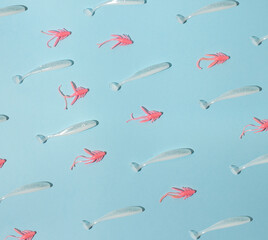 Pattern of pink bugs and white fishes on blue background. Pastel, natural concept. Fishing lures.