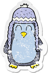 retro distressed sticker of a cartoon penguin wearing hat