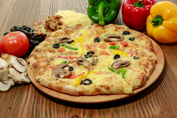 Chicken and mushroom pie pizza with bell pepper, black olive, tomato and cheese served in wooden board isolated on table side view of arabic food