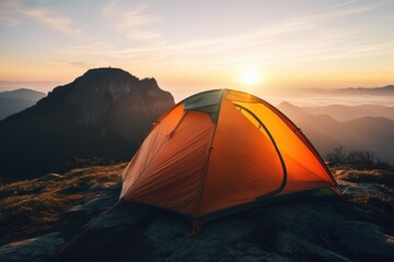 A tent pitched on top of a mountain at sunset. Perfect for adventure and outdoor travel concepts
