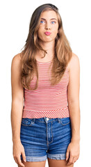 Obraz premium Beautiful caucasian young woman wearing casual clothes puffing cheeks with funny face. mouth inflated with air, crazy expression.