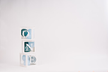 Cardboard cubes with the inscription ONE balloons in blue color on a white background. Birthday concept. Copy space