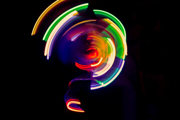 Abstract multi-colored light , swirl and curve of blue, green and red bright light tracks against a...