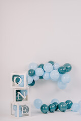 Cardboard cubes with the inscription ONE balloons in blue color on a white background. Birthday concept. Copy space