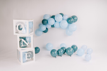 Cardboard cubes with the inscription ONE balloons in blue color on a white background. Birthday concept. Copy space