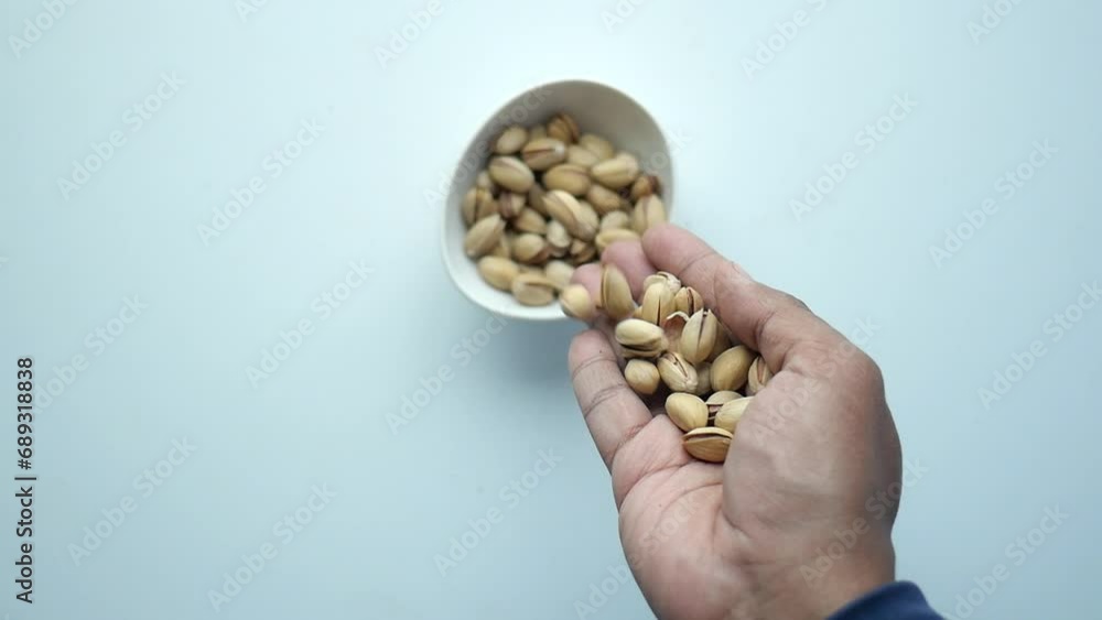 Poster slow motion of dropping pistachios nuts in a bowl, top view  - Posters