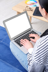 Female web designer with laptop sitting on sofa