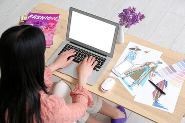 Female designer working with laptop on table