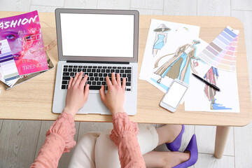 Female designer working with laptop on table